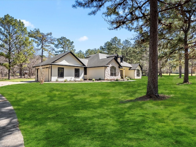 view of front of property with stone siding, driveway, a front yard, and a garage