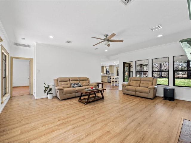 living room featuring recessed lighting, visible vents, light wood-style flooring, and crown molding