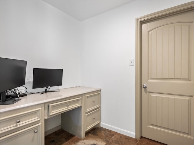 office space featuring stone finish flooring and baseboards