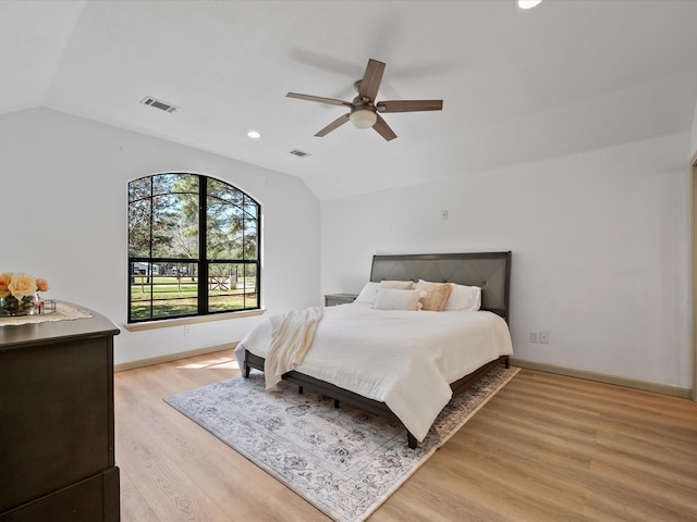 bedroom featuring light wood finished floors, visible vents, and lofted ceiling