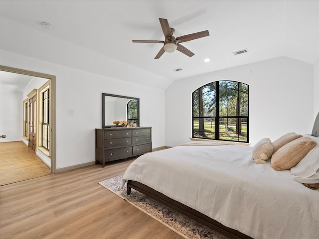 bedroom with visible vents, lofted ceiling, baseboards, and light wood-style flooring