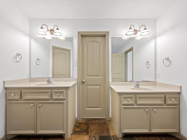 full bath with stone finish floor, two vanities, and a sink