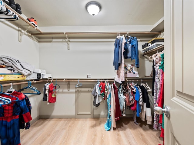 walk in closet with wood finished floors