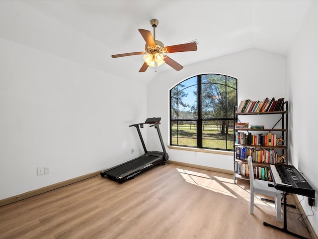 workout area with vaulted ceiling, a ceiling fan, baseboards, and light wood finished floors