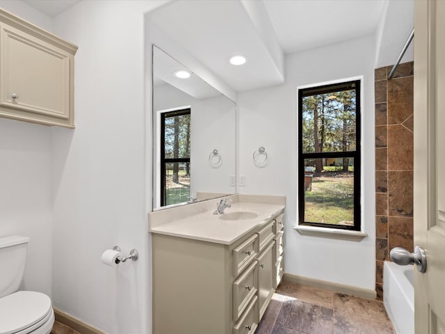 full bath with a wealth of natural light, toilet, vanity, and baseboards