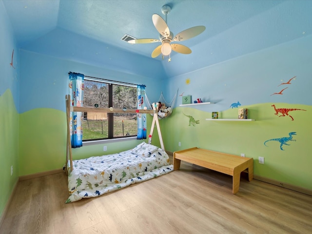 bedroom featuring wood finished floors, visible vents, baseboards, ceiling fan, and vaulted ceiling