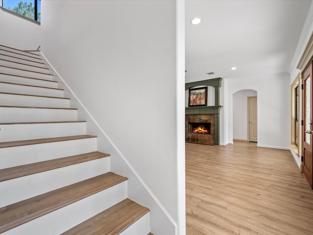 staircase with wood finished floors, visible vents, a fireplace, recessed lighting, and arched walkways