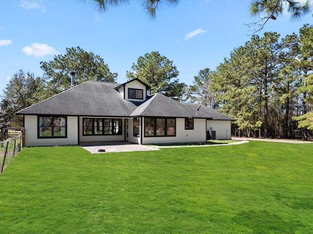 back of house with a yard, a patio, a shingled roof, and fence