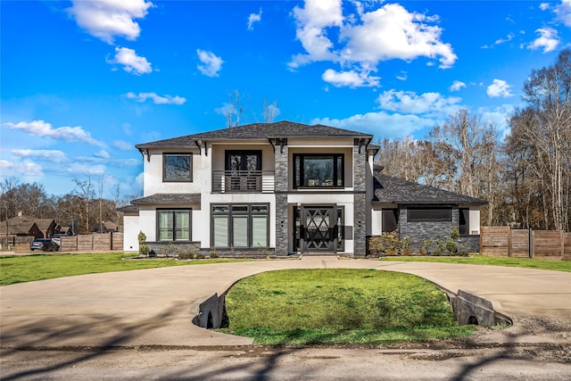 view of front of home featuring a balcony and a front lawn