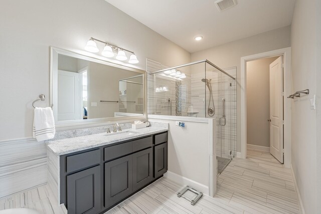 bathroom featuring walk in shower and vanity