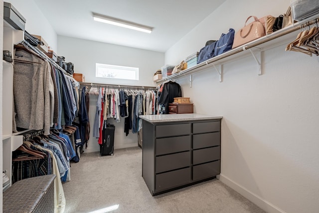 walk in closet with light carpet