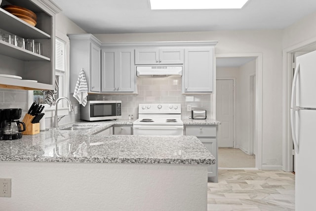 kitchen featuring sink, white appliances, light stone counters, decorative backsplash, and kitchen peninsula