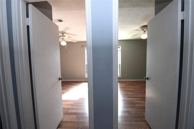 hall featuring hardwood / wood-style flooring and a textured ceiling