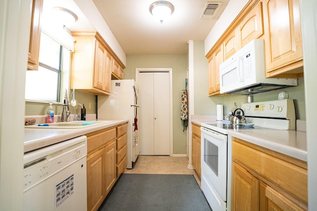 kitchen with sink, light brown cabinets, and white appliances