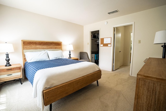 carpeted bedroom with a walk in closet and a closet