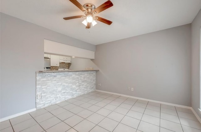 tiled spare room featuring ceiling fan