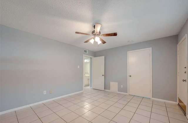 tiled empty room featuring a textured ceiling and ceiling fan