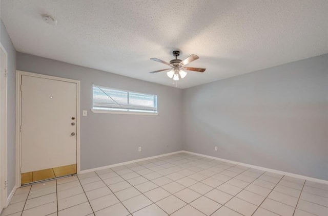 tiled spare room featuring a textured ceiling and ceiling fan