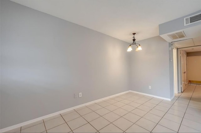 spare room with light tile patterned floors and an inviting chandelier