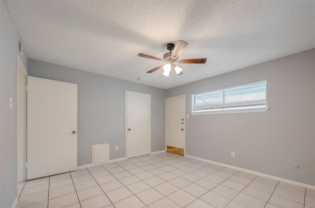 unfurnished room featuring light tile patterned floors, a textured ceiling, and ceiling fan