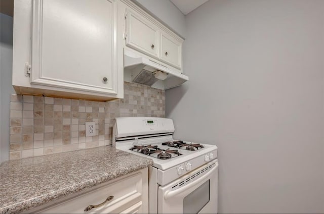 kitchen featuring tasteful backsplash, white cabinetry, and white gas stove