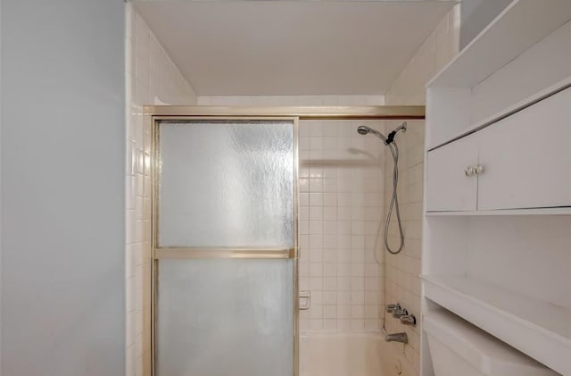 bathroom with bath / shower combo with glass door and toilet