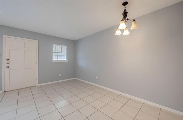 empty room featuring light tile patterned floors and a notable chandelier