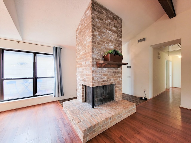 unfurnished living room featuring a fireplace, dark hardwood / wood-style flooring, and vaulted ceiling with beams