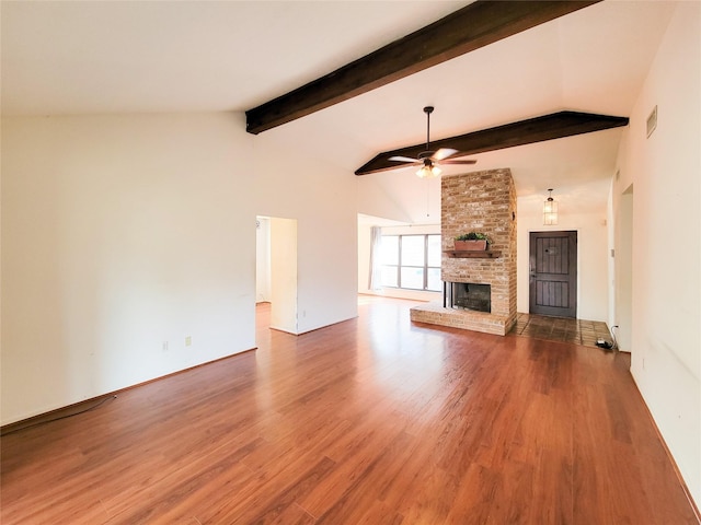 unfurnished living room with ceiling fan, dark hardwood / wood-style floors, a brick fireplace, and vaulted ceiling with beams