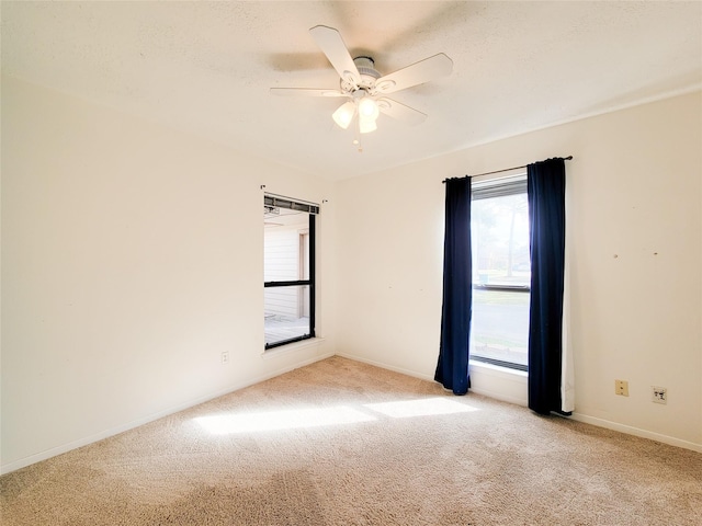 spare room featuring a textured ceiling, light colored carpet, and ceiling fan