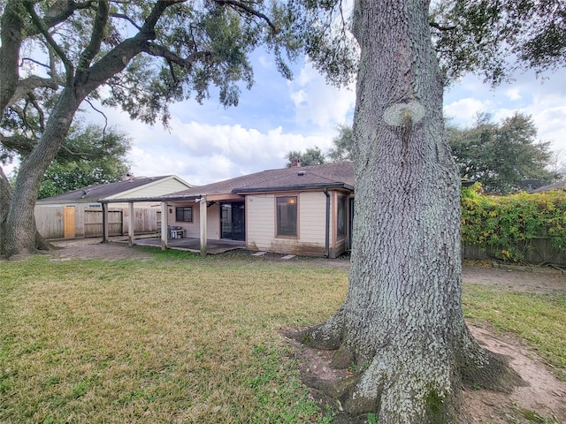 back of house with a yard and a patio area