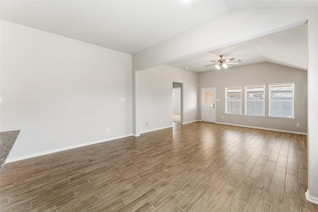 unfurnished living room with a ceiling fan, vaulted ceiling, baseboards, and wood finished floors