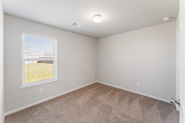 empty room with carpet, plenty of natural light, visible vents, and baseboards