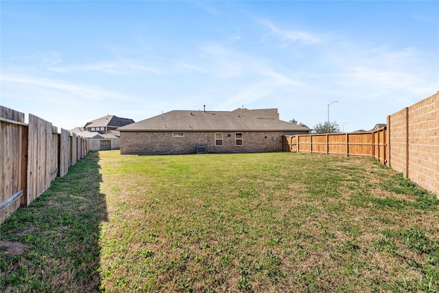 view of yard featuring central AC and a fenced backyard