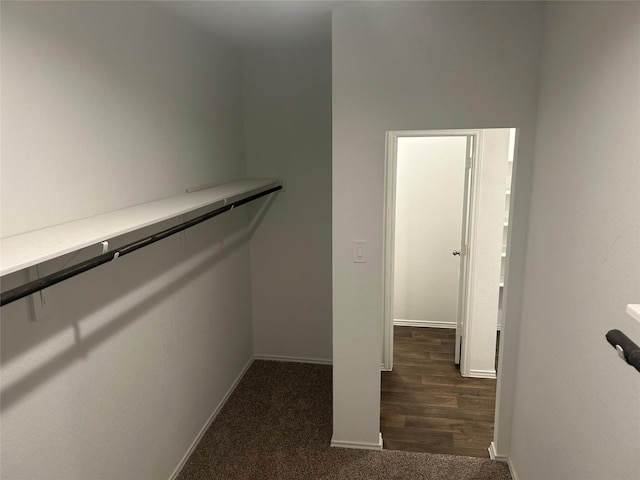 spacious closet featuring dark colored carpet