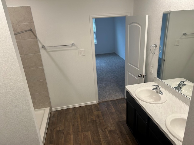 bathroom with hardwood / wood-style flooring, vanity, and walk in shower