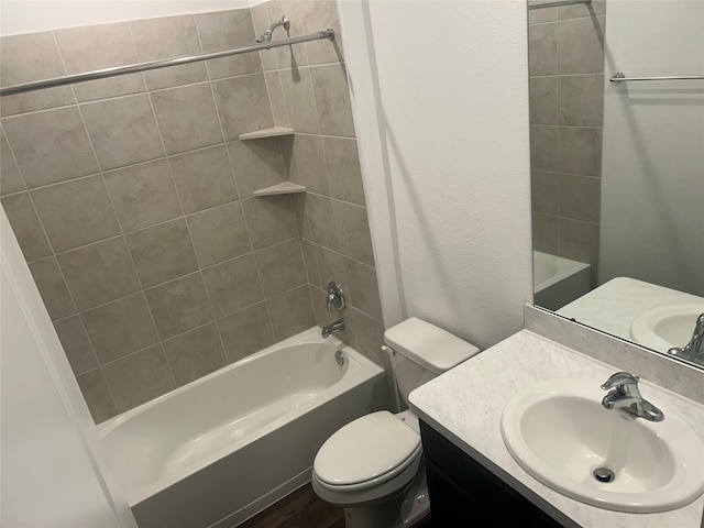 full bathroom featuring tiled shower / bath, vanity, and toilet