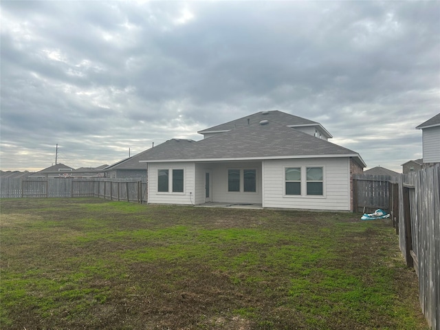 rear view of house featuring a yard and a patio