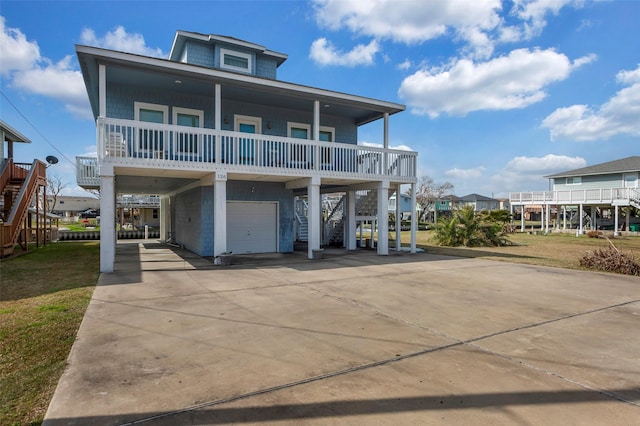 rear view of property with a carport, a balcony, and a garage