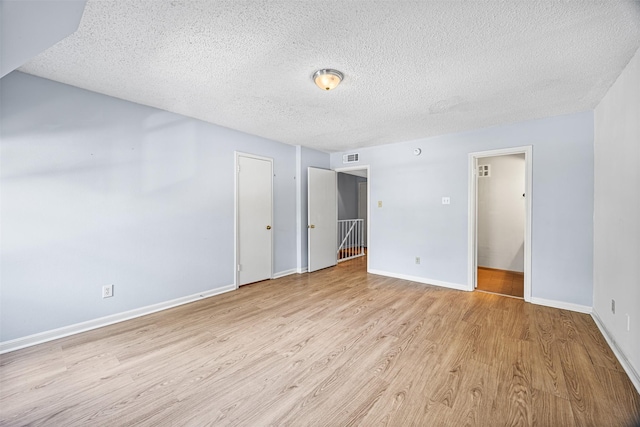 unfurnished bedroom with light hardwood / wood-style flooring and a textured ceiling