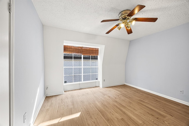 spare room featuring ceiling fan, light hardwood / wood-style flooring, and a textured ceiling