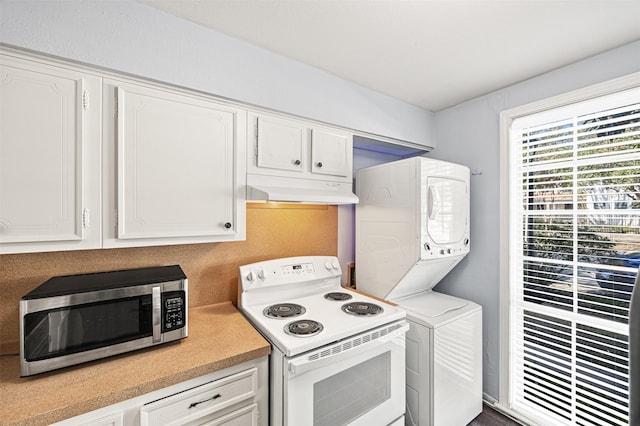 kitchen featuring white cabinetry, stacked washing maching and dryer, and electric stove