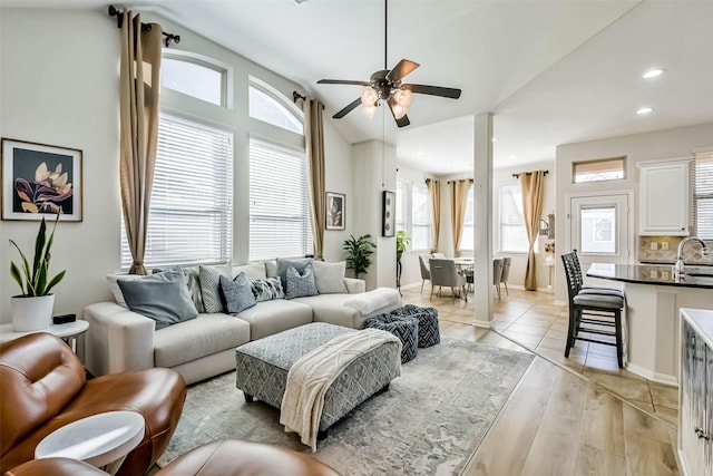 living room featuring vaulted ceiling, ceiling fan, light hardwood / wood-style floors, and sink