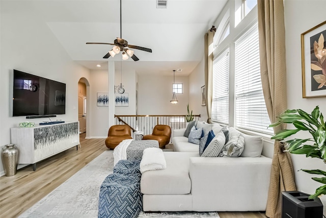 living room with vaulted ceiling, ceiling fan, and light hardwood / wood-style flooring