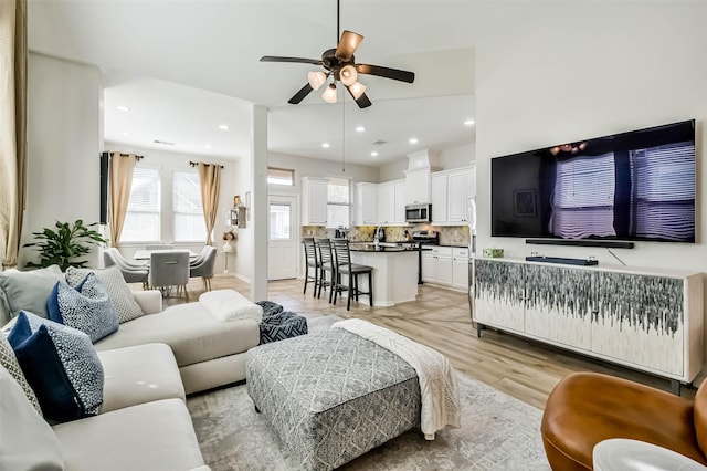 living room featuring ceiling fan and light hardwood / wood-style flooring