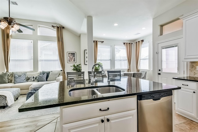 kitchen with dishwasher, sink, dark stone countertops, and white cabinets