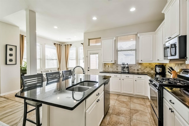 kitchen featuring sink, a center island with sink, white cabinets, and appliances with stainless steel finishes