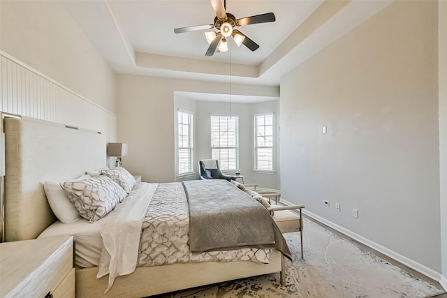 bedroom with a raised ceiling and ceiling fan