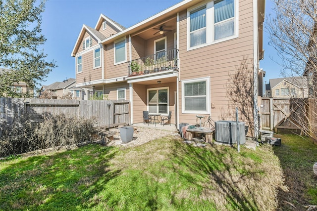 back of house featuring a lawn, ceiling fan, cooling unit, a patio area, and a balcony