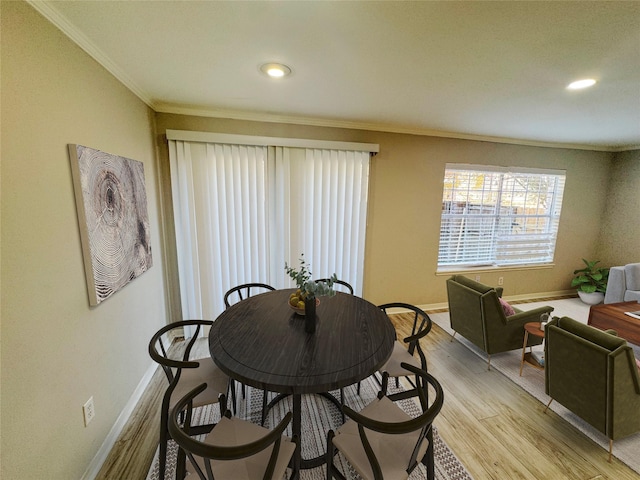 dining space featuring crown molding and light hardwood / wood-style floors